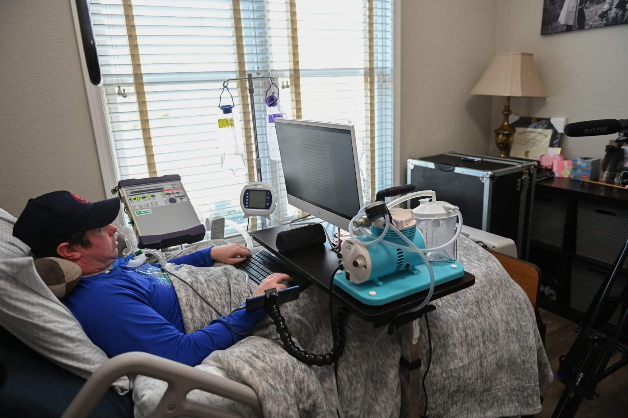 Person with ALS in bed with computer