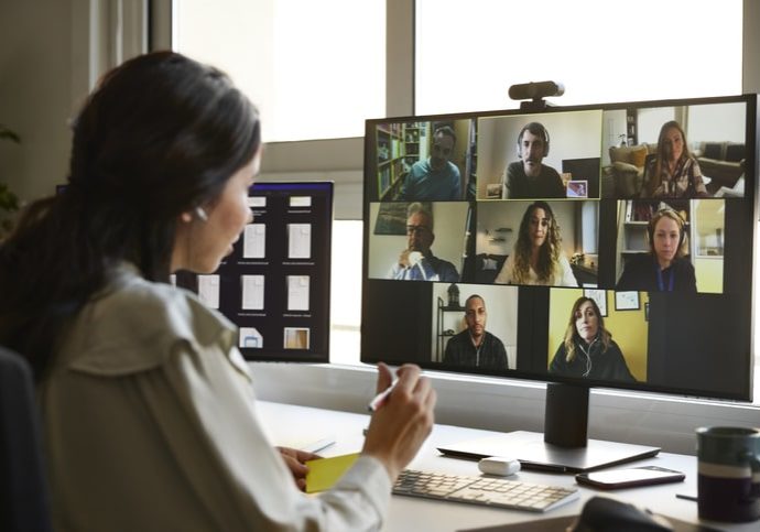 Businesswoman discussing with colleagues during video conference. Male and female entrepreneurs attending online meeting. They are planning business strategy.