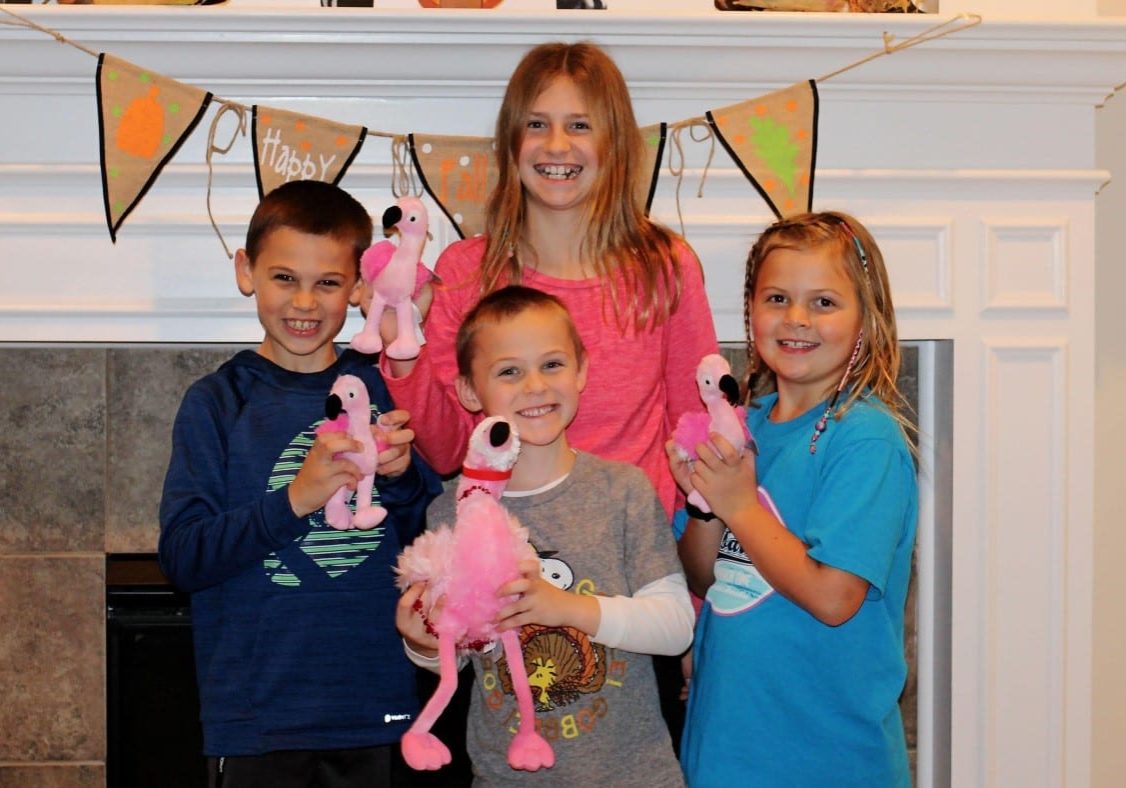 Kids with stuffed flamingos from backpacks